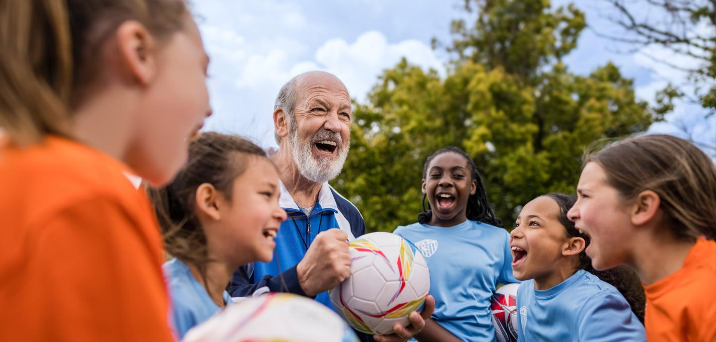Coach wearing hearing aids celebrating with children athletes